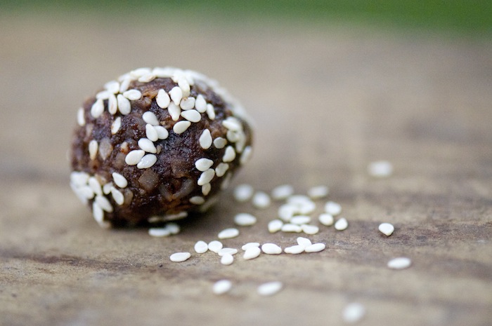 A naturally sweet date ball is covered in sesames