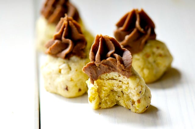 Three chocolate topped shortbread cookies on a white counter.