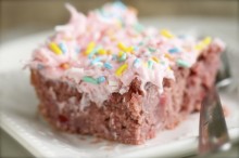 One slice of strawberry cake with fruity frosting and a fork to help you eat it with!