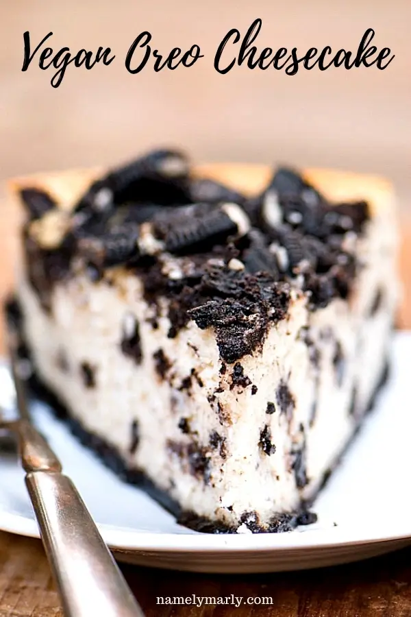 A slice of cheesecake sits on a plate with a work beside it. The text above it reads, Vegan Oreo Cheesecake.