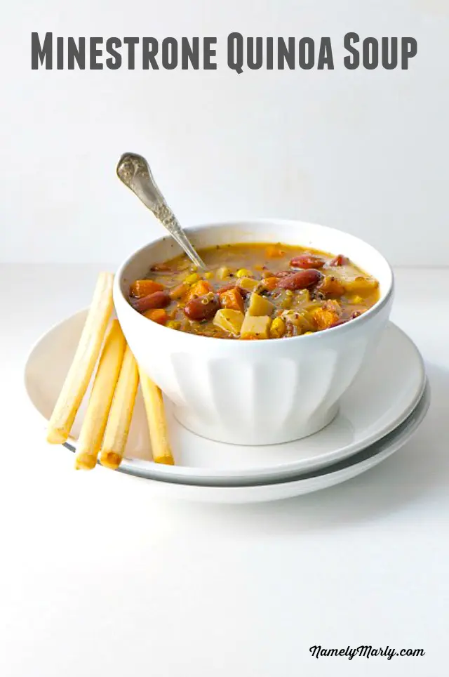 A bowl holds soup with a spoon in it. It sits on a plate with several bread sticks. The text above it reads, Minestrone Quinoa Soup.
