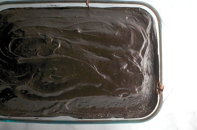 A 9X13 glass pan holds the freshly iced chocolate chai cake.