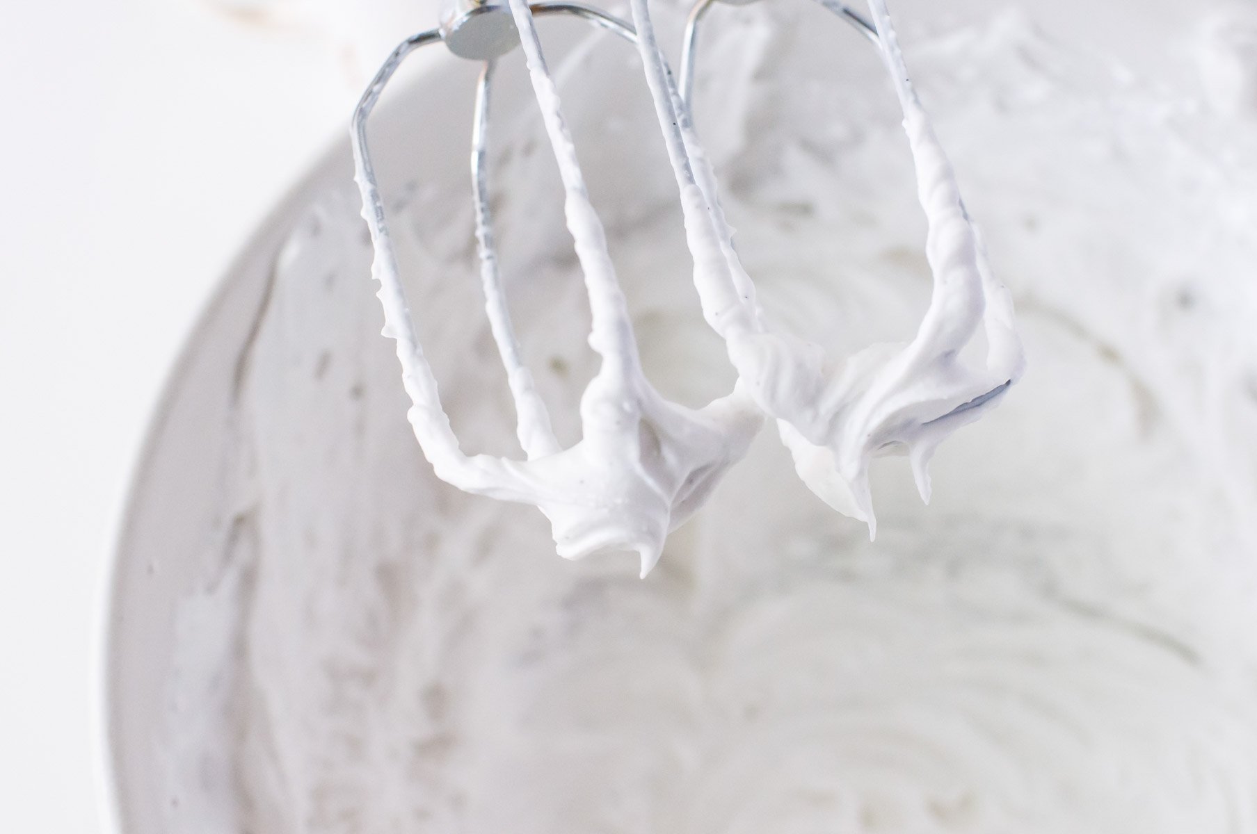 Looking at the beaters coming out of the bowl of coconut fat, showing peaks to create whipped topping.