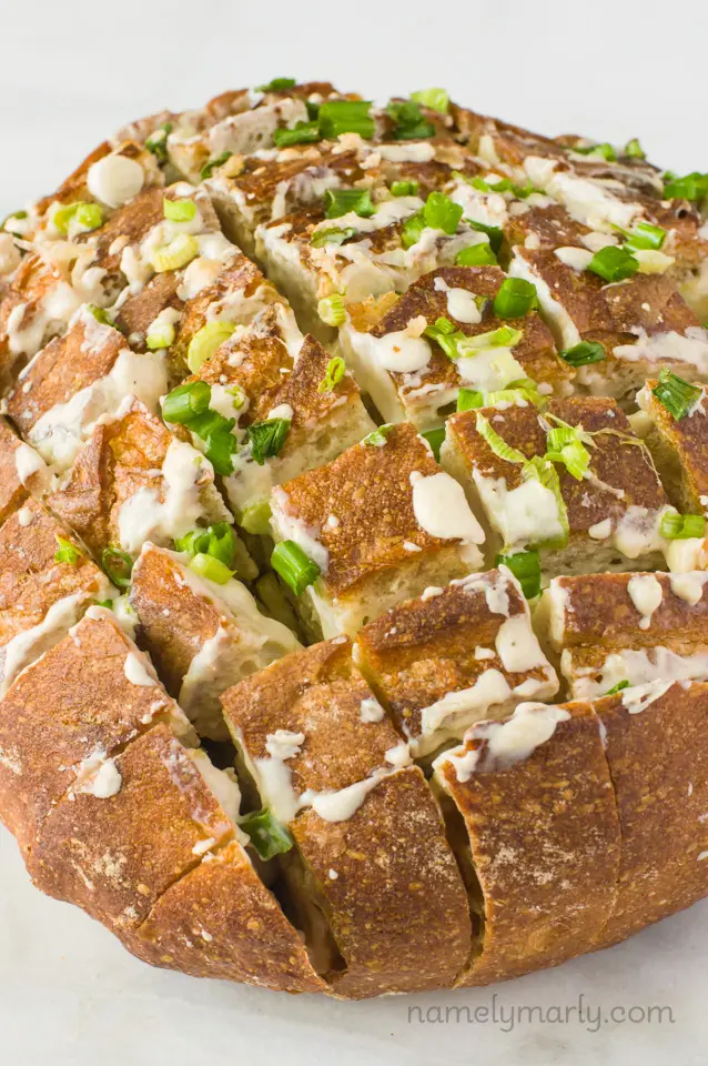 A round loaf has been cut in several different directions to create pieces that pull-apart easily. 
