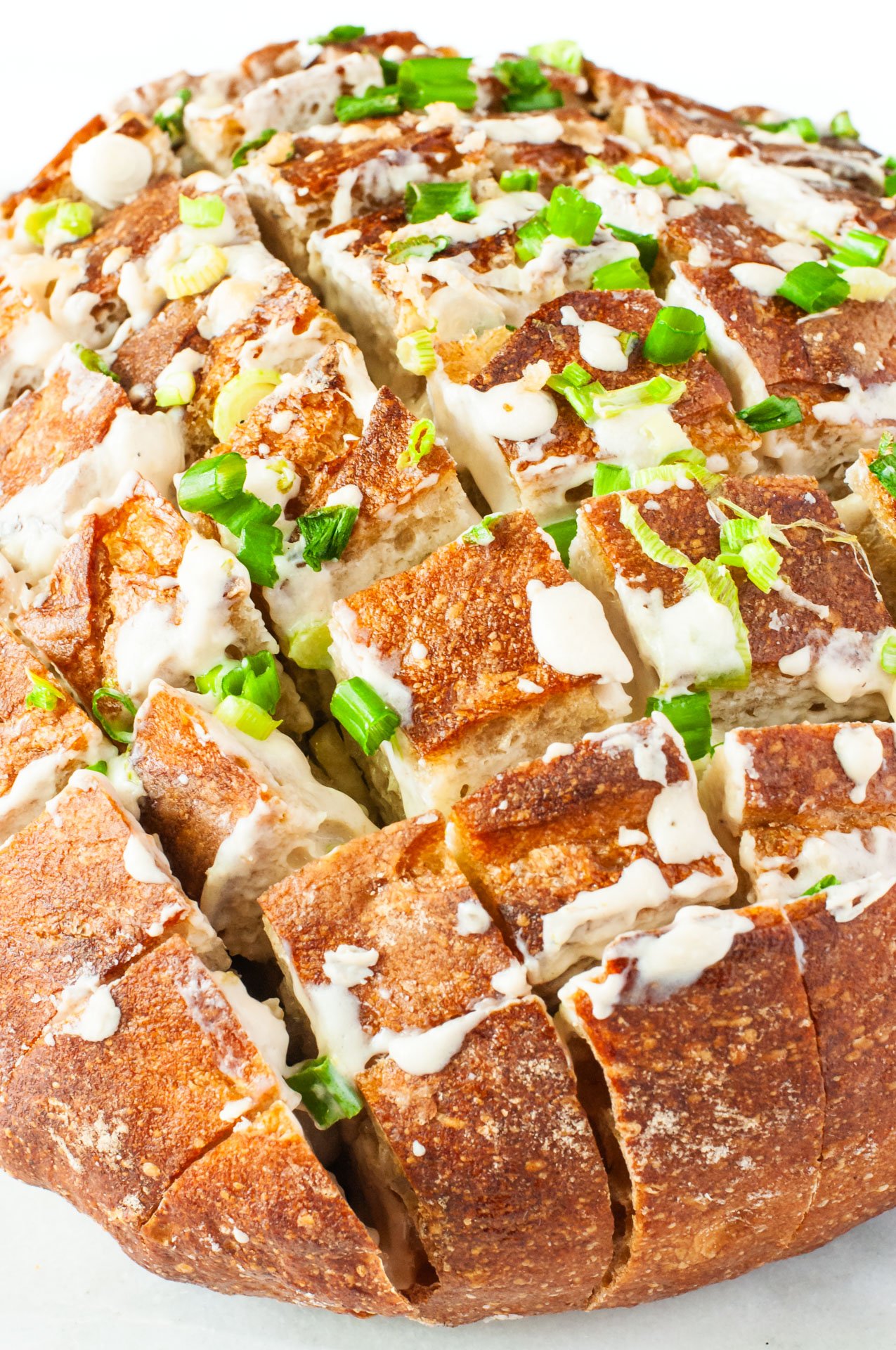 A round loaf has been cut in several different directions to create pieces that pull-apart easily. 