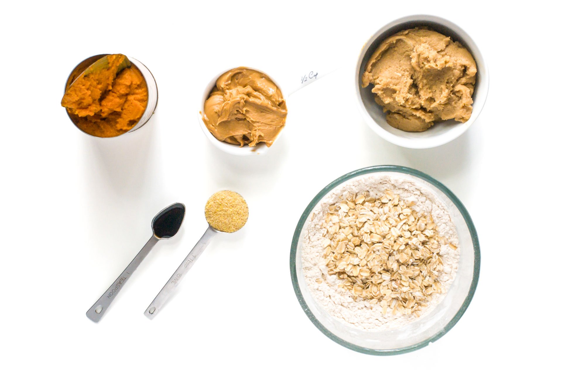 A mise en place of ingredients for vegan pumpkin pie bars, including pumpkin, oatmeal, and more.