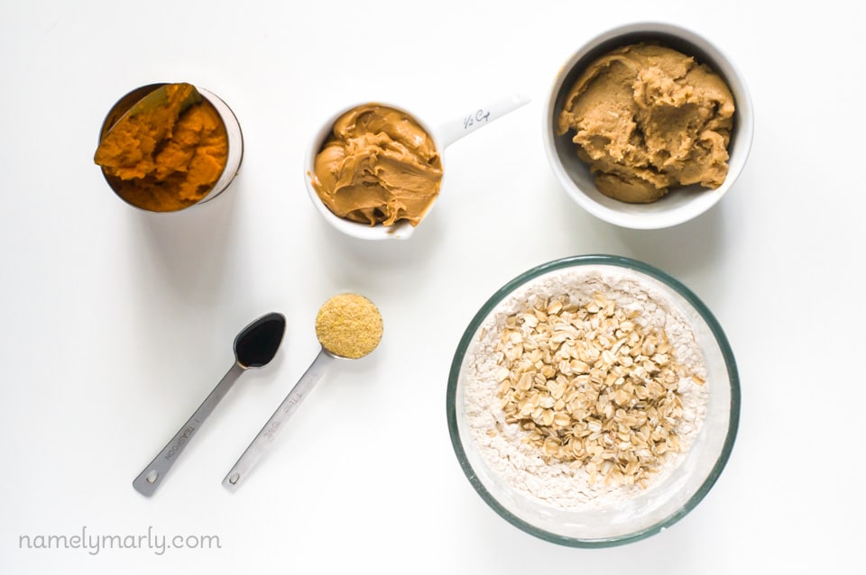 A mise en place of ingredients for vegan pumpkin pie bars, including pumpkin, oatmeal, and more.