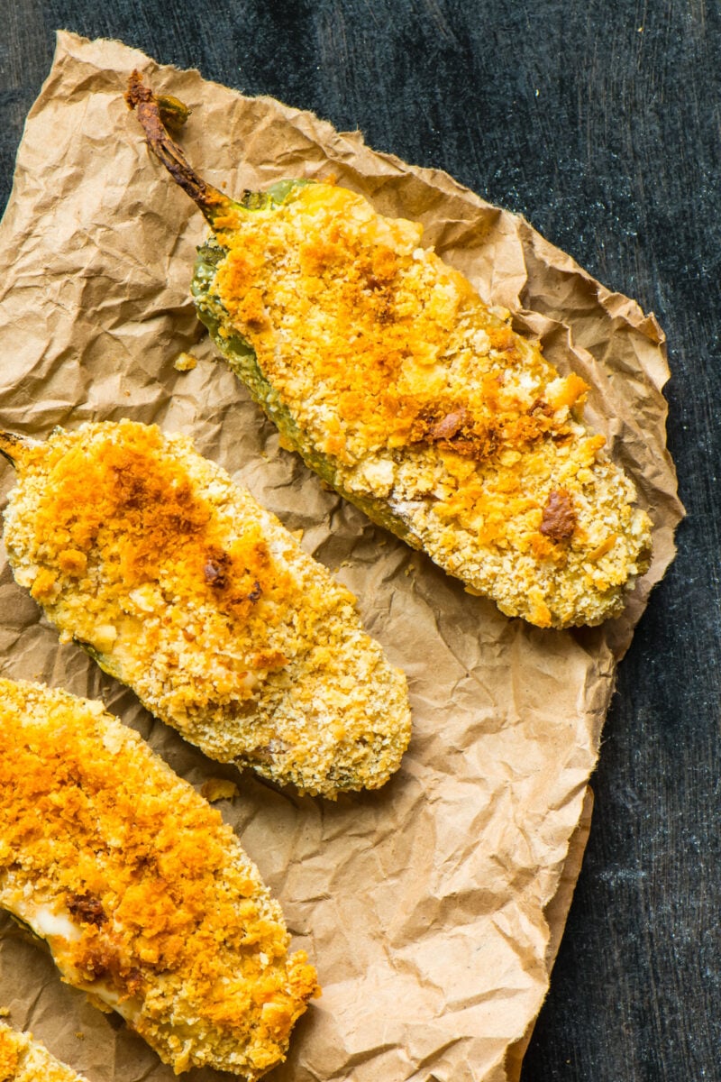 A closeup of vegan baked jalapeño poppers on a paper.