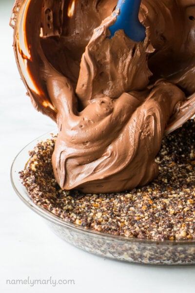 Chocolate pie filling is being poured into a chocolate crust.