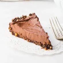A slice of vegan chocolate pie on a doily next to a fork
