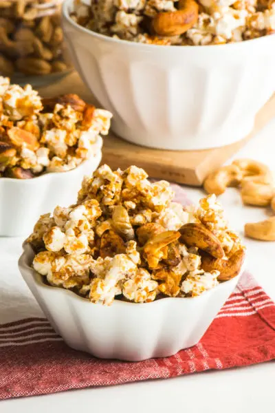 Vegan Cinnamon Popcorn Trail Mix in a small serving bowl with a larger bowl full of it behind it.
