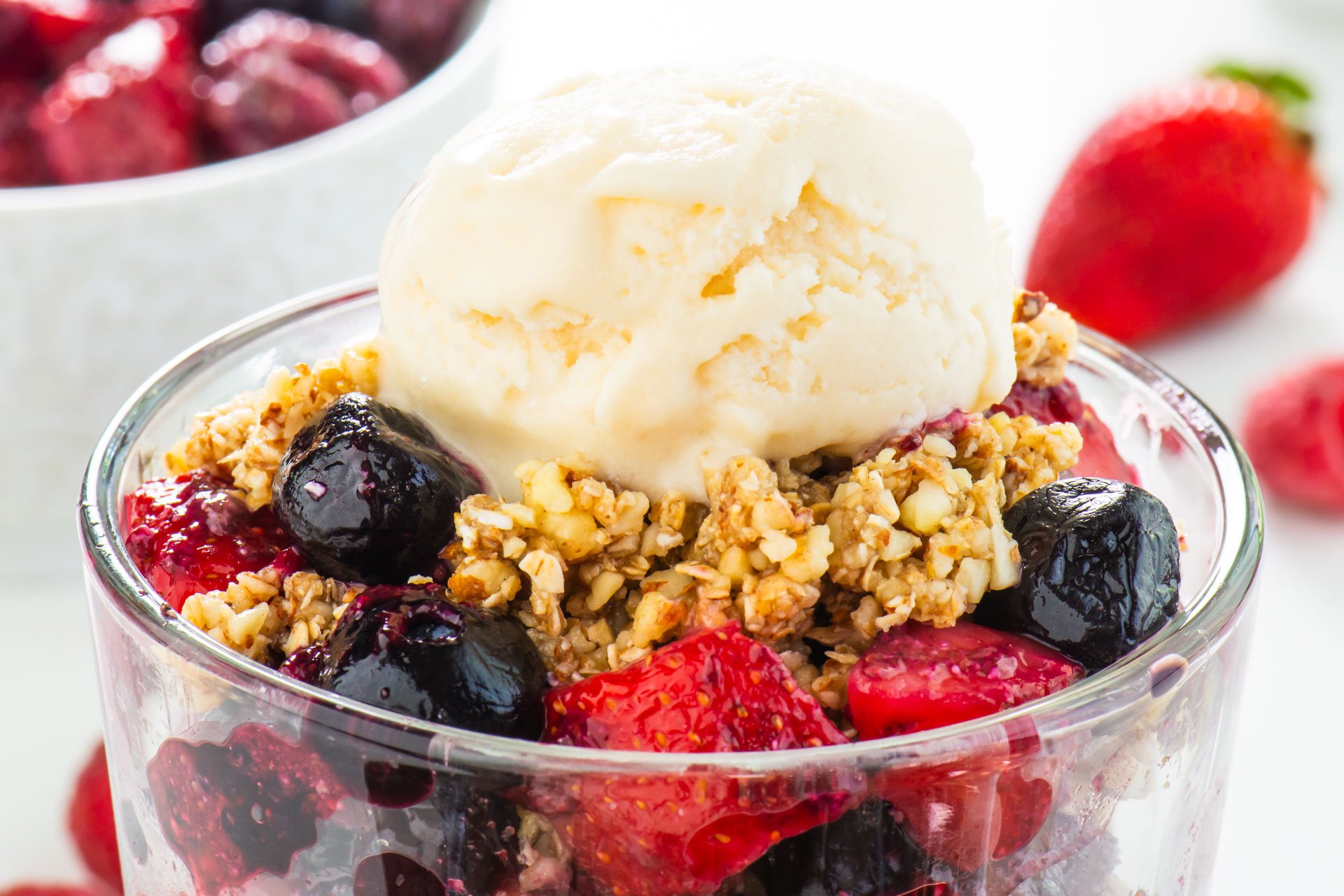 Vegan No-Bake Cherry Fruit Crisp in a serving dish with ice cream on top.