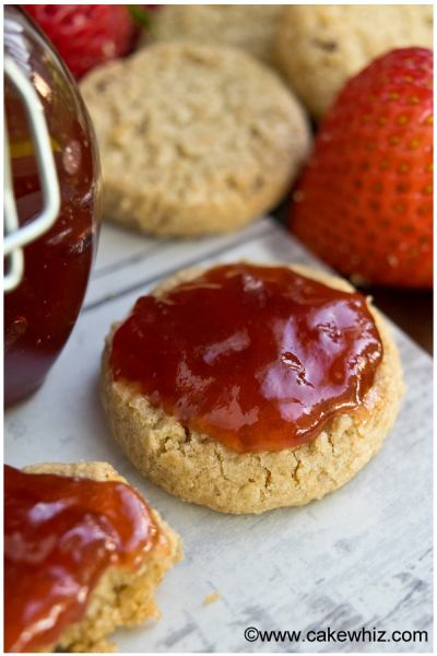 Biscuits have been cut in half and are topped with strawberry jam.