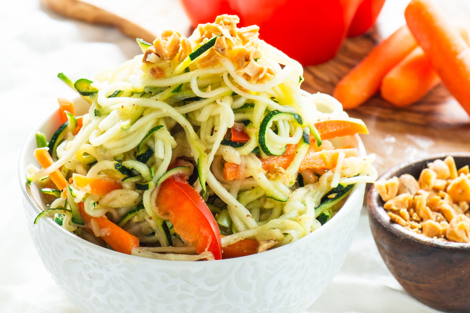 Spicy Vegan Pad Thai Zucchini Noodles are drizzled in a spicy, tangy sauce and topped with chopped peanuts.