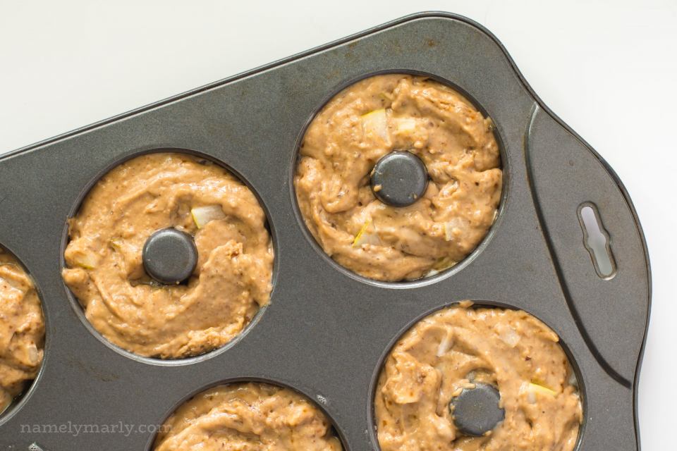A donut pan has compartments full of batter.