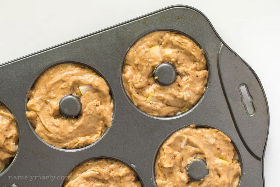 A donut pan has compartments full of batter.
