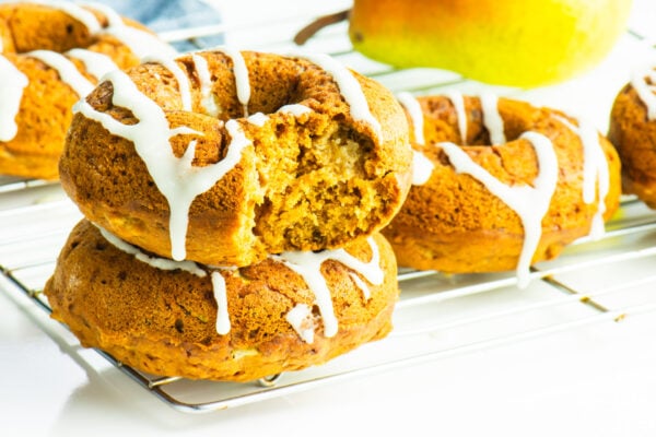 Vegan Baked Ginger Pear Donuts stacked on a baking rack