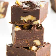 A stack of three pieces of vegan fudge sit in front of more pieces.