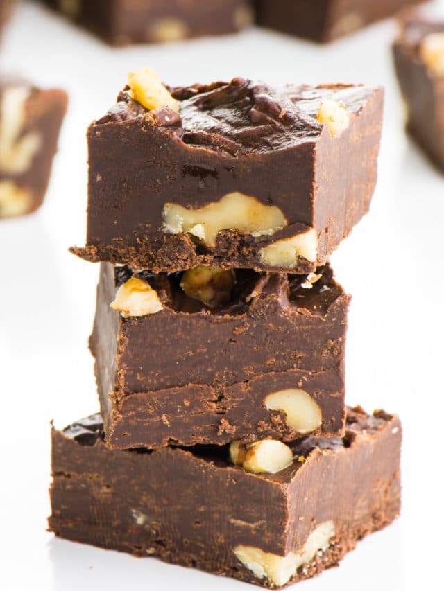A stack of three pieces of vegan fudge sit in front of more pieces.