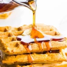 A pitcher is pouring syrup over a stack of waffles and the syrup is dripping over the edges. The text at the top reads, Whole Wheat Crispy Waffles.