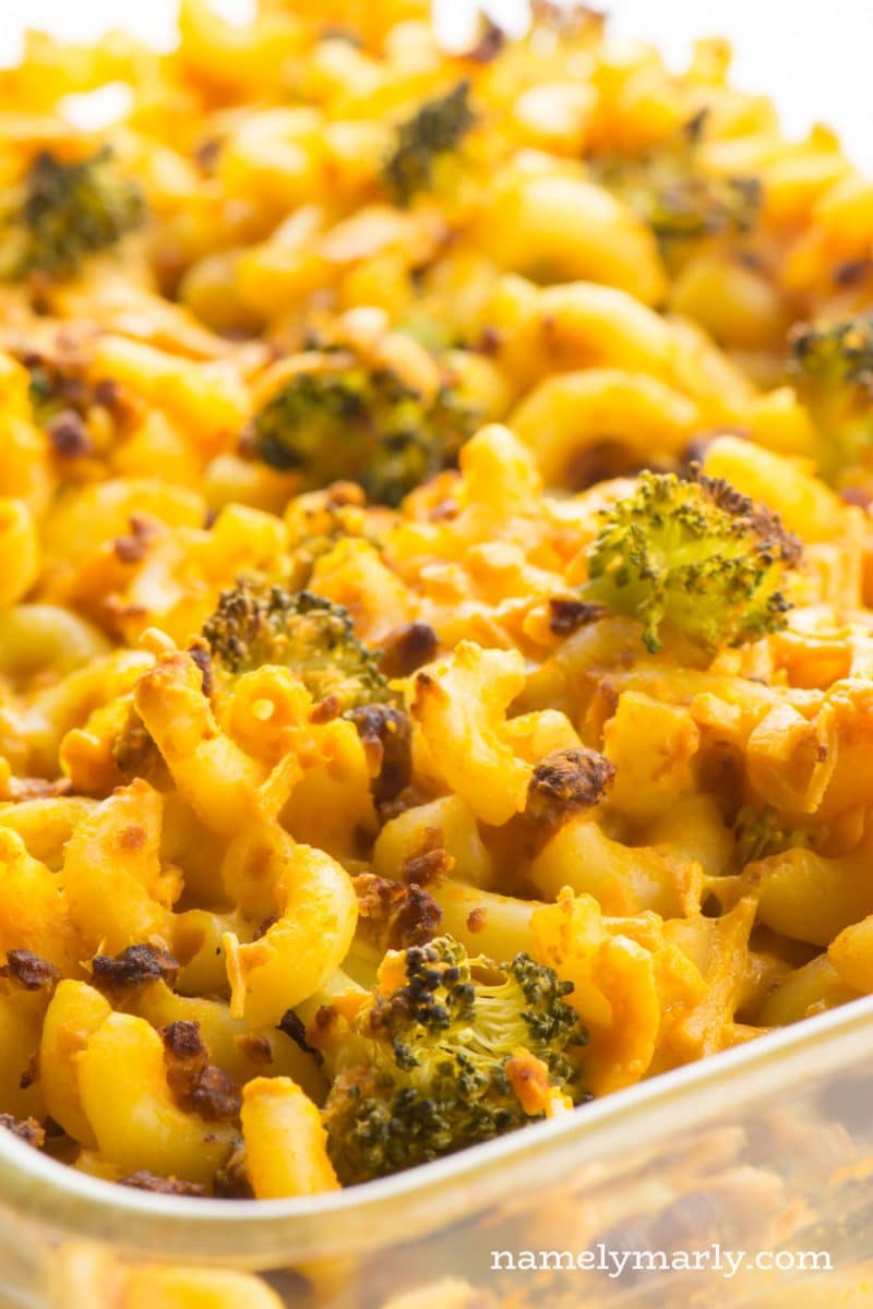 Vegan Macaroni and Cheese with steamed broccoli and veggie crumbles in a casserole dish.