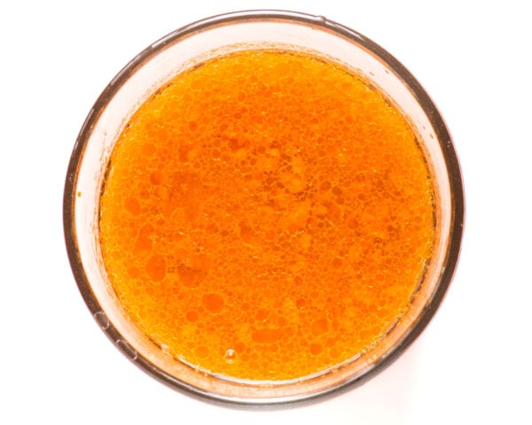 The wet ingredients for this healthy carrot cake recipe are in a glass mixing bowl.