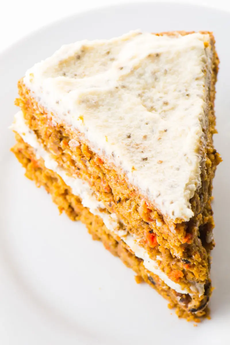 Looking down on a slice of healthy carrot cake sitting on a white plate.
