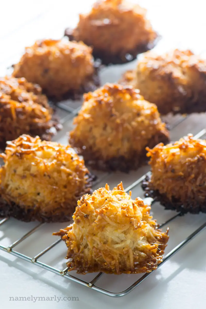 Coconut macaroons sit on a wire rack to cool.