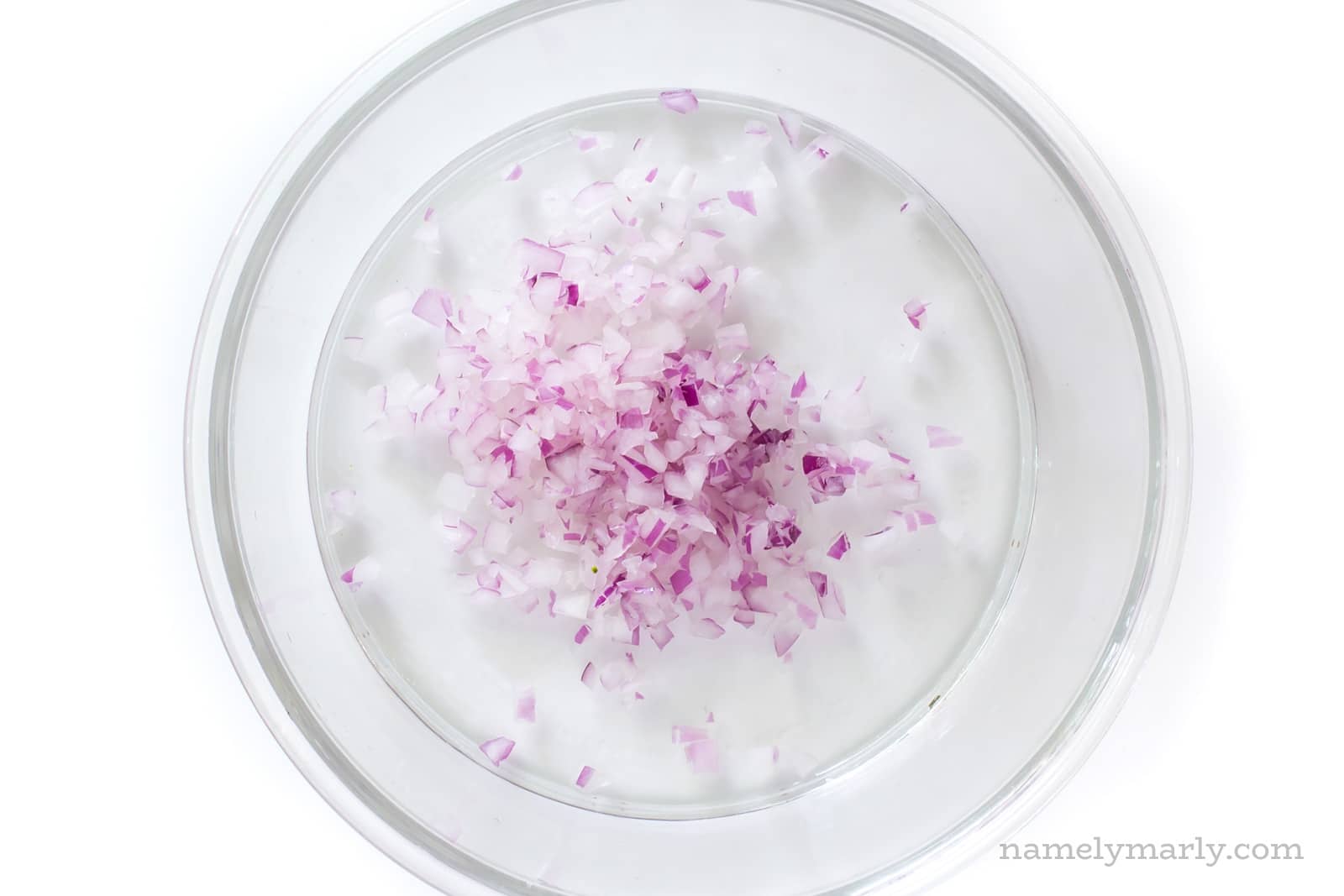 Chopped onions in the bottom of a glass bowl
