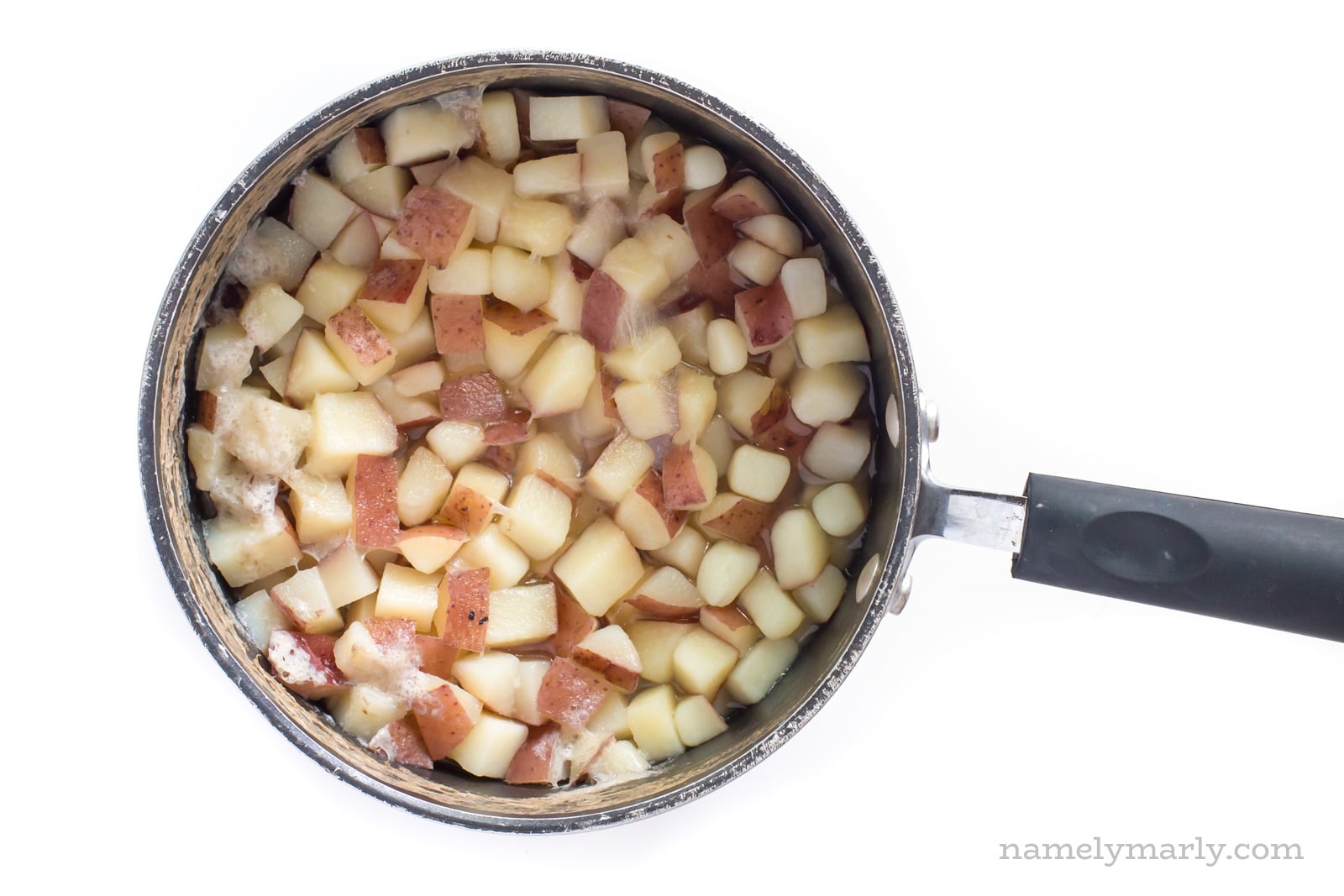 A pot of boiled, chopped potatoes.