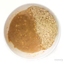 Oats have been combined with a liquid mixture in a bowl.