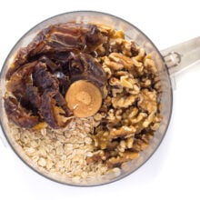 Oatmeal, dates, and walnuts in a food processor bowl.