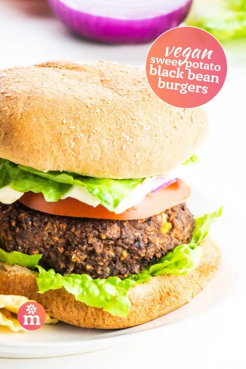 A closeup of a burger on a bun with common burger toppings. The text reads, Vegan Sweet Potato Black Bean Burgers.