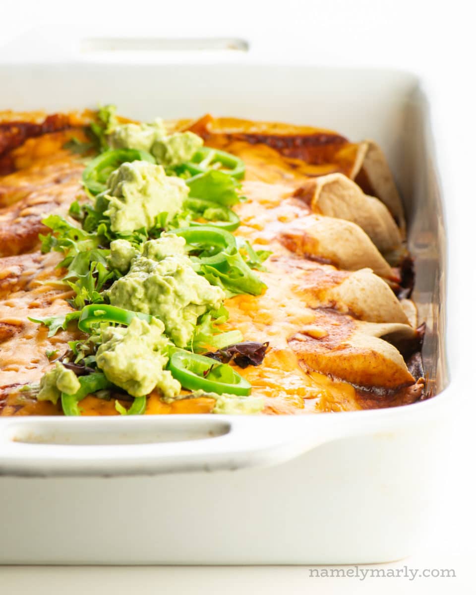 A baking dish full of vegan enchiladas fresh from the oven.