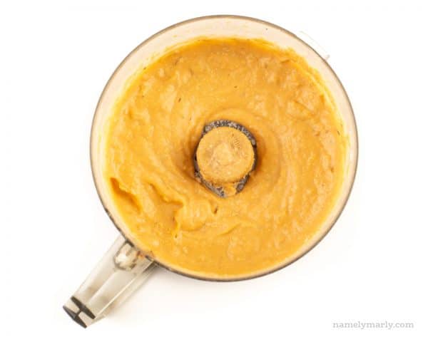 Looking down on pureed sweet potato mixture in a food processor bowl.
