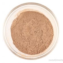 Cocoa powder has been mixed with flour and other dry ingredients and sits in the bottom of a glass mixing bowl.