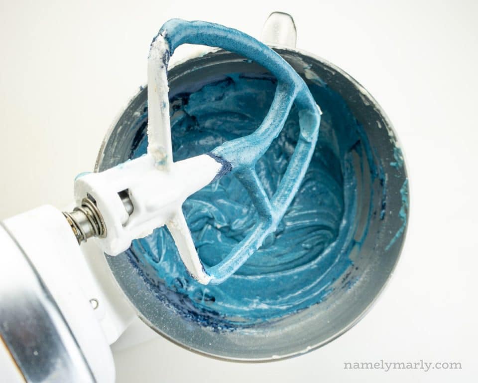 Blue cake batter in a mixing bowl of a stand mixer.