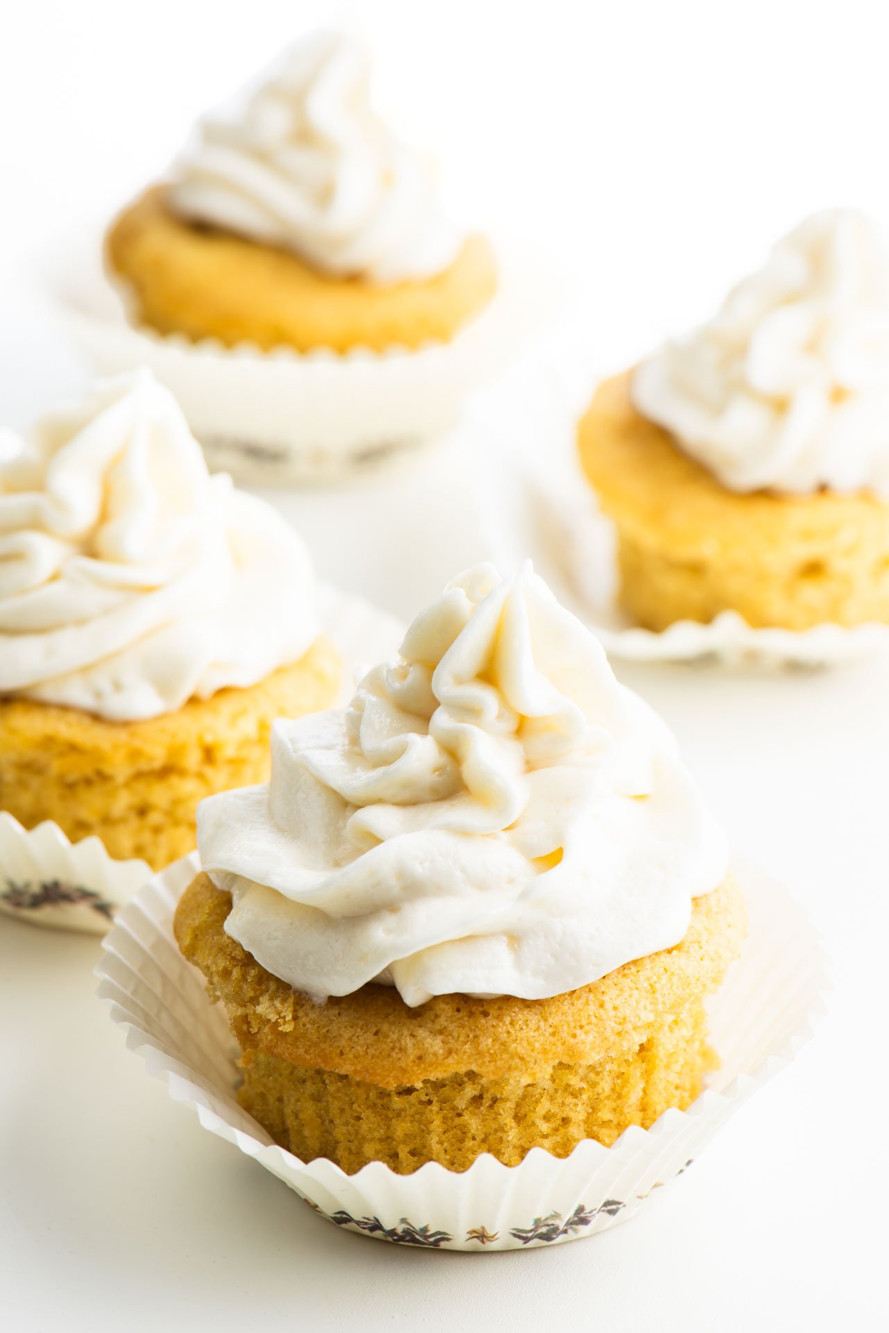 Four frosted cupcakes sit next to each other.