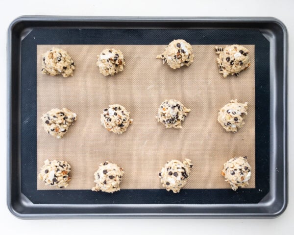 Looking down on a baking sheet with cookie dough balls ready to be baked.