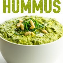 An image of green hummus in a bowl topped with chopped greens and pine nuts. The text above it reads: Green Monster Hummus.