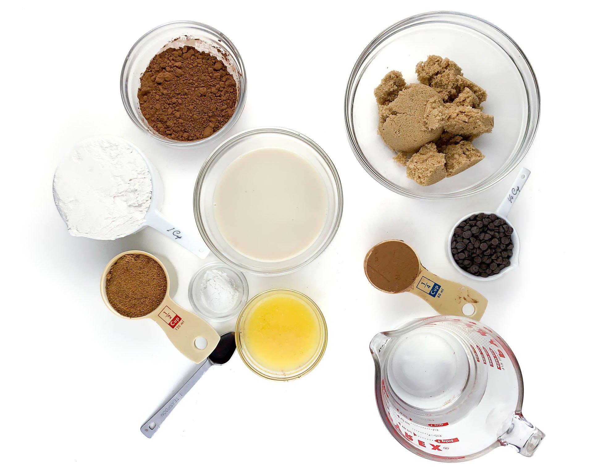 The ingredients to make a dessert recipe are laid out in bowls and measuring cups.