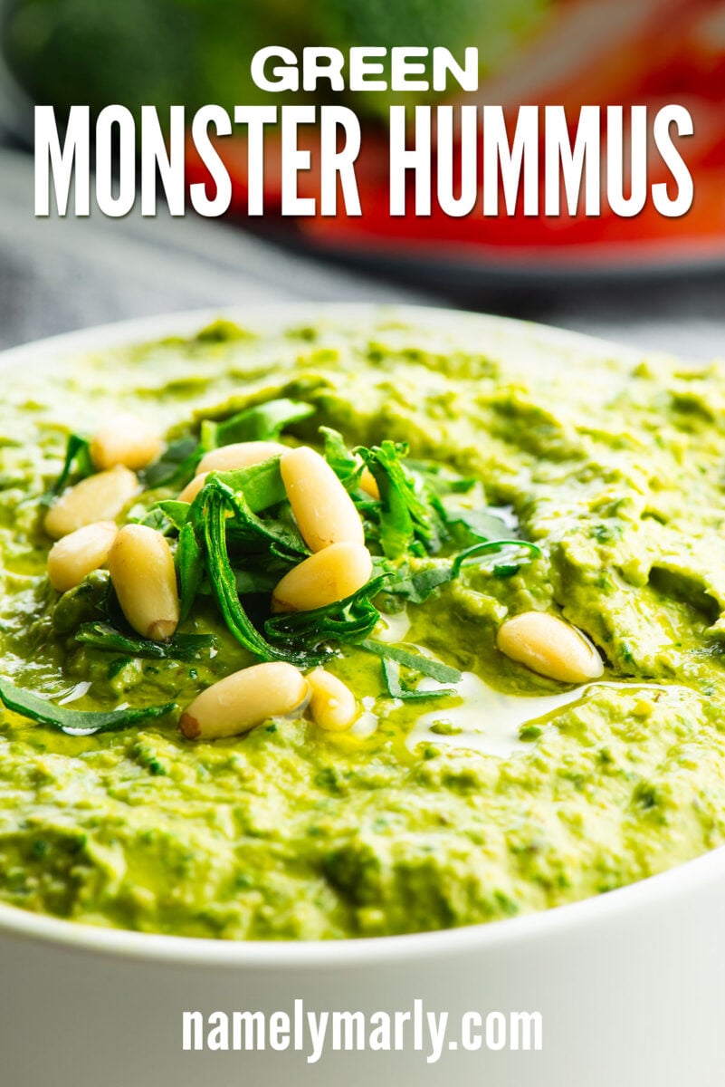 a bowl of green hummus topped with pine nuts and text that reads green monster hummus
