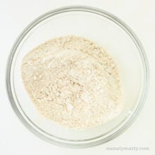 A flour mixture is in a glass bowl.
