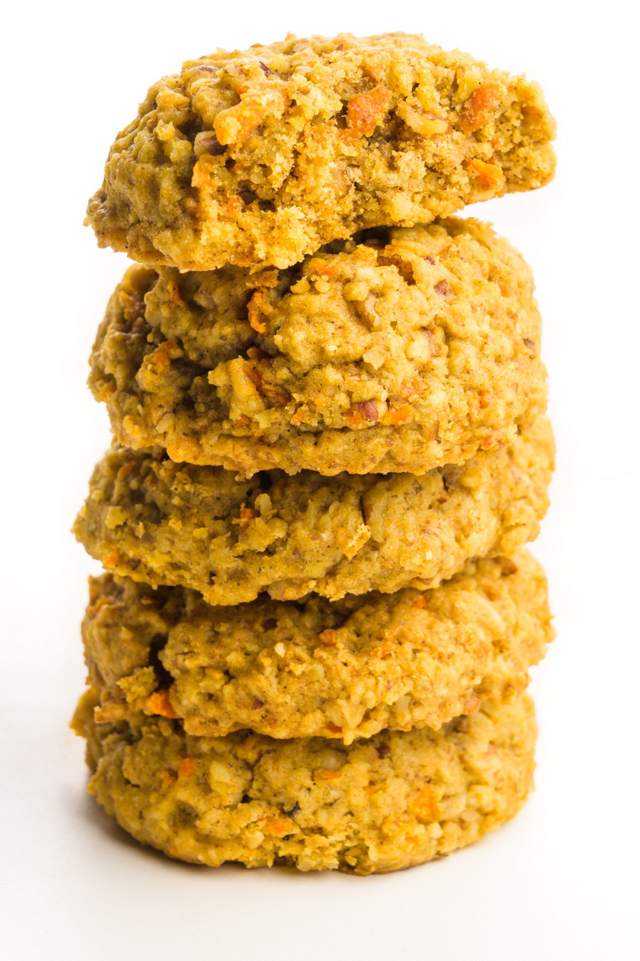 A stack of cookies with the top cookie having a bite taken out of it.