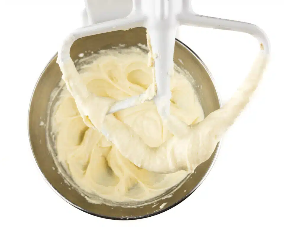 A creamy mixture is in a stand mixer.