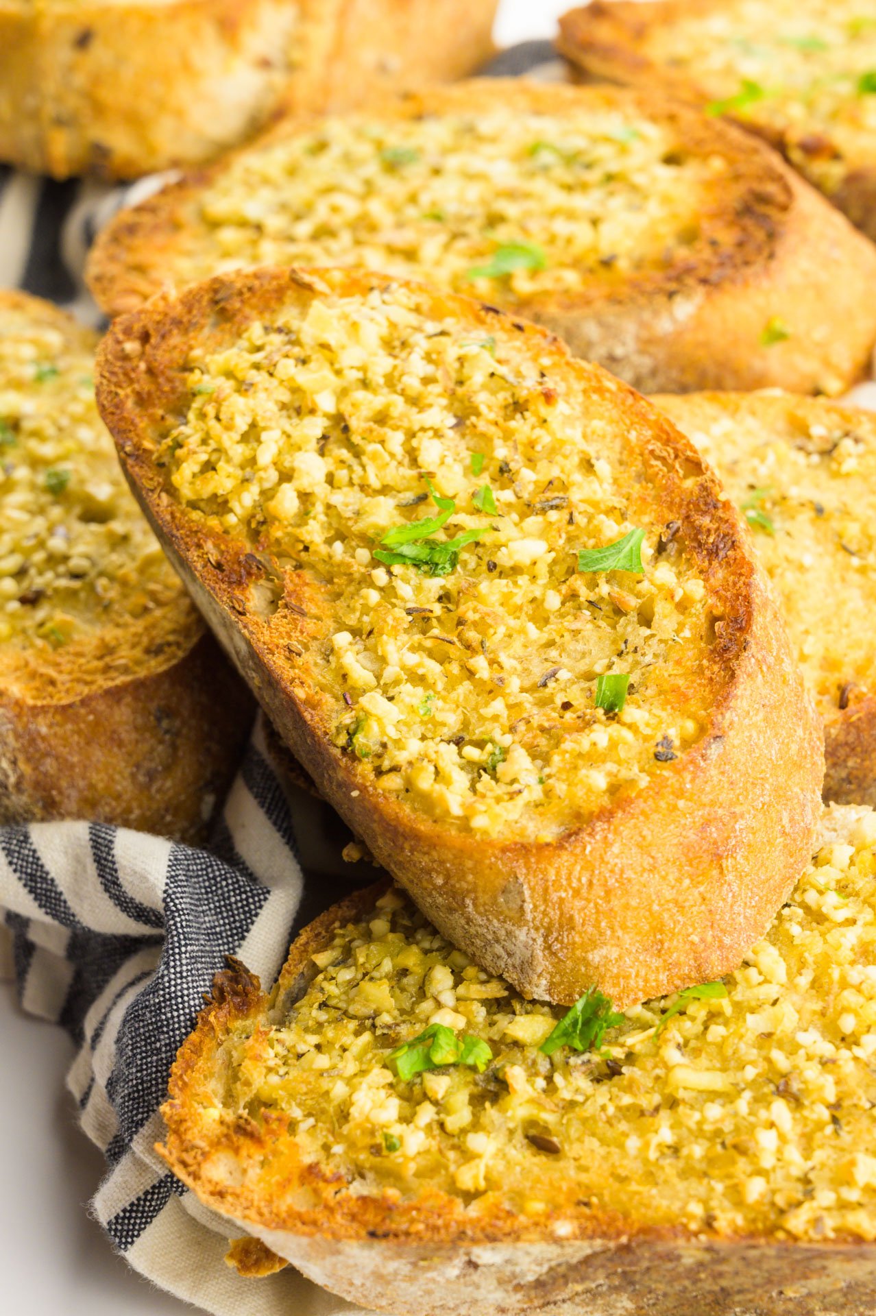 Looking down on several slices of toasted bread with herbs on top.