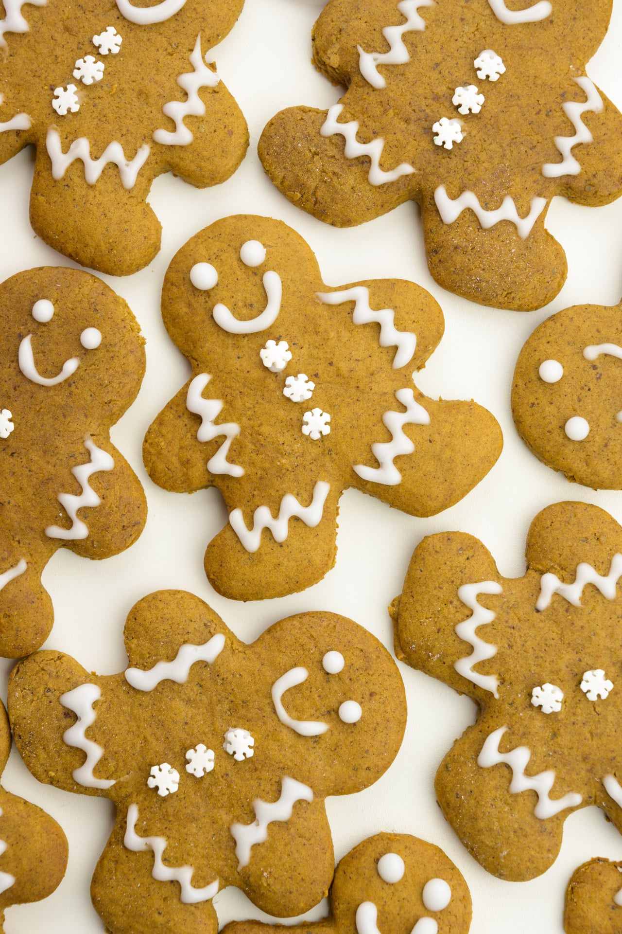 Several decorated vegan gingerbread cookies are on a white background.