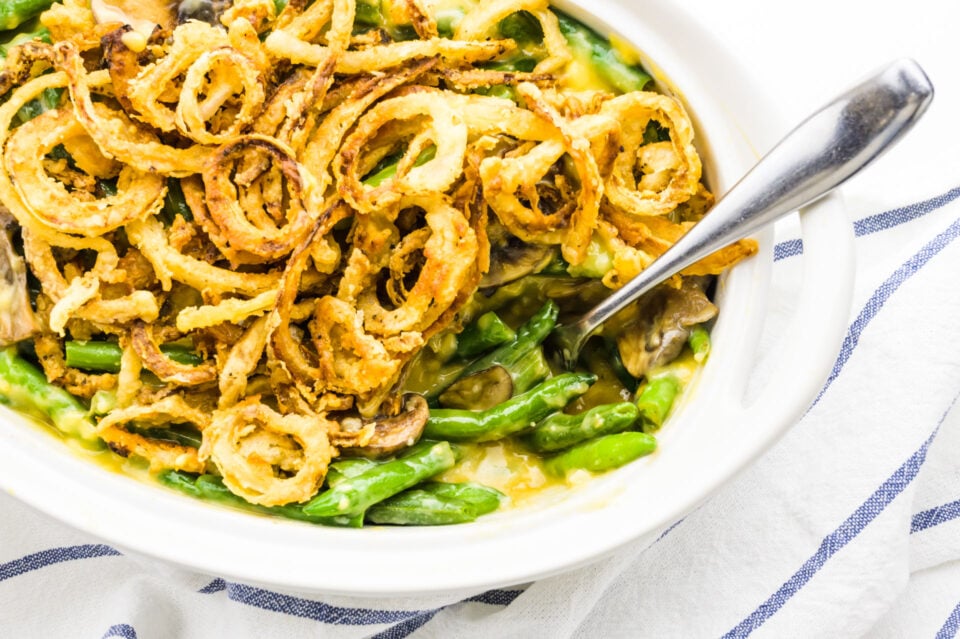 Looking down on a spoon in a casserole dish full of green bean casserole.