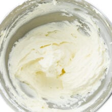 Looking down on a mixing bowl full of fluffy white frosting.