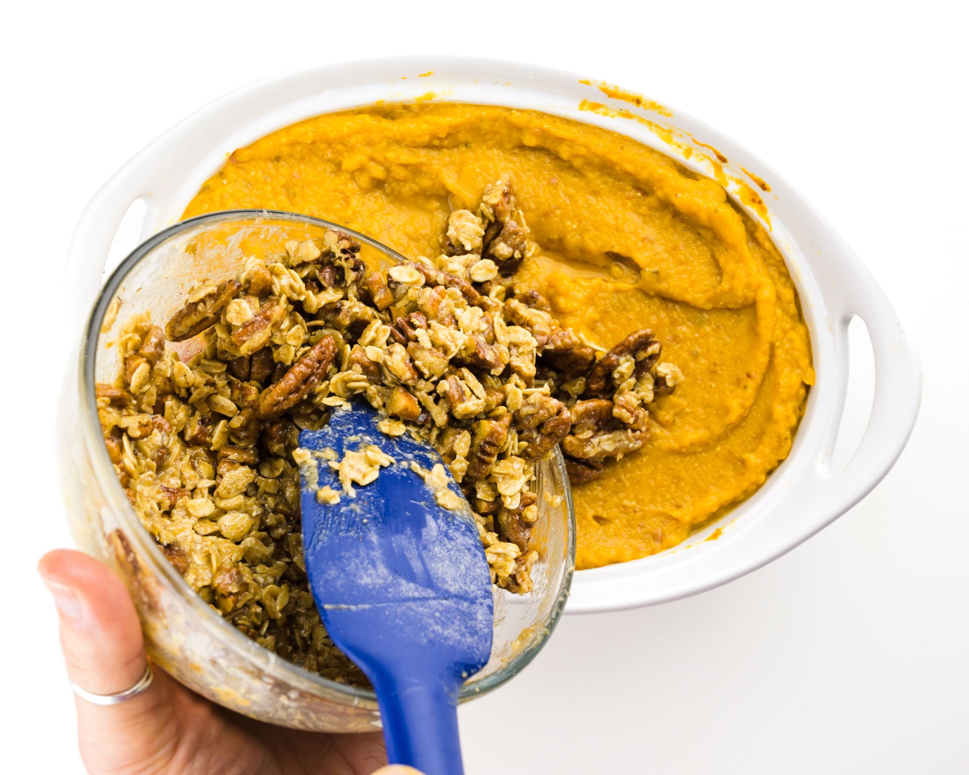 Pouring crumble topping over the sweet potato casserole.